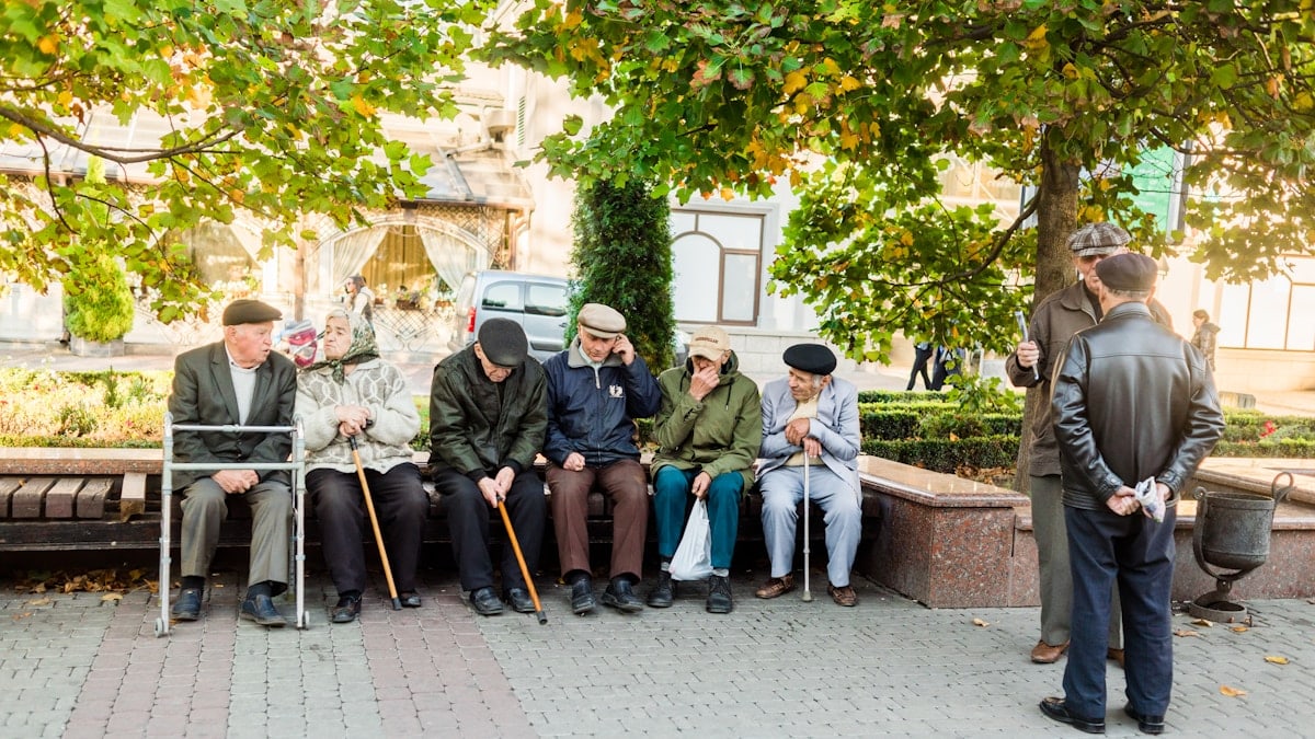 a group of people sitting next to each other on a bench